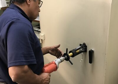 Technician drilling a safe